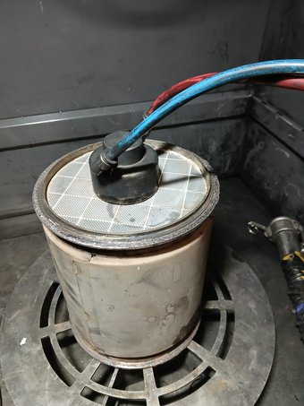 Cylindrical diesel particulate filter connected to a cleaning hose
