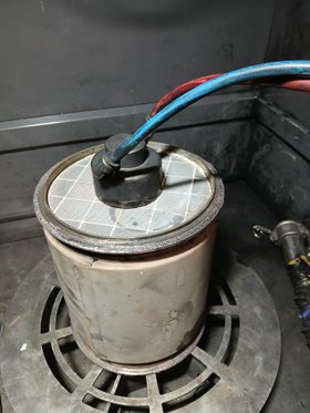 Cylindrical diesel particulate filter connected to a cleaning hose
